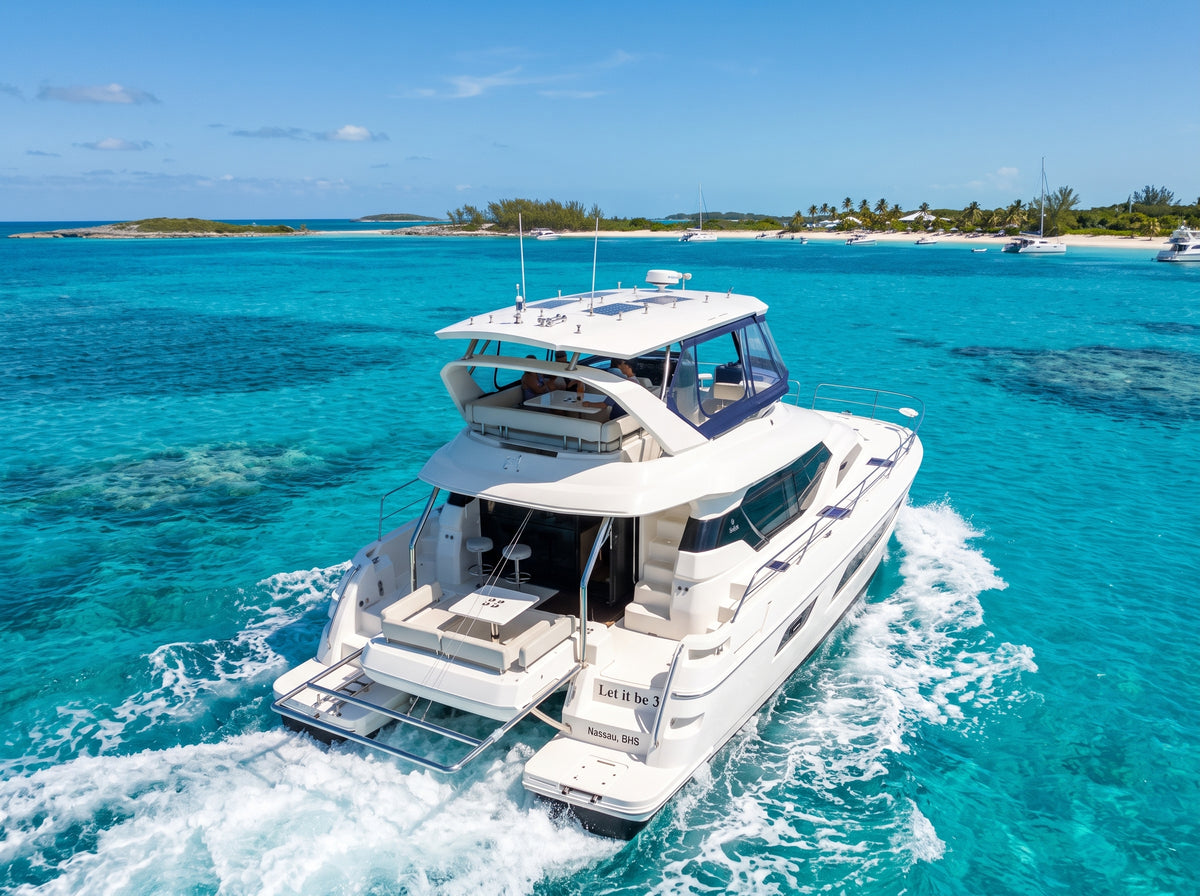 Aerial of the 44ft Aquila Let it be 3 leaving a wake above a reef in the Bahamas