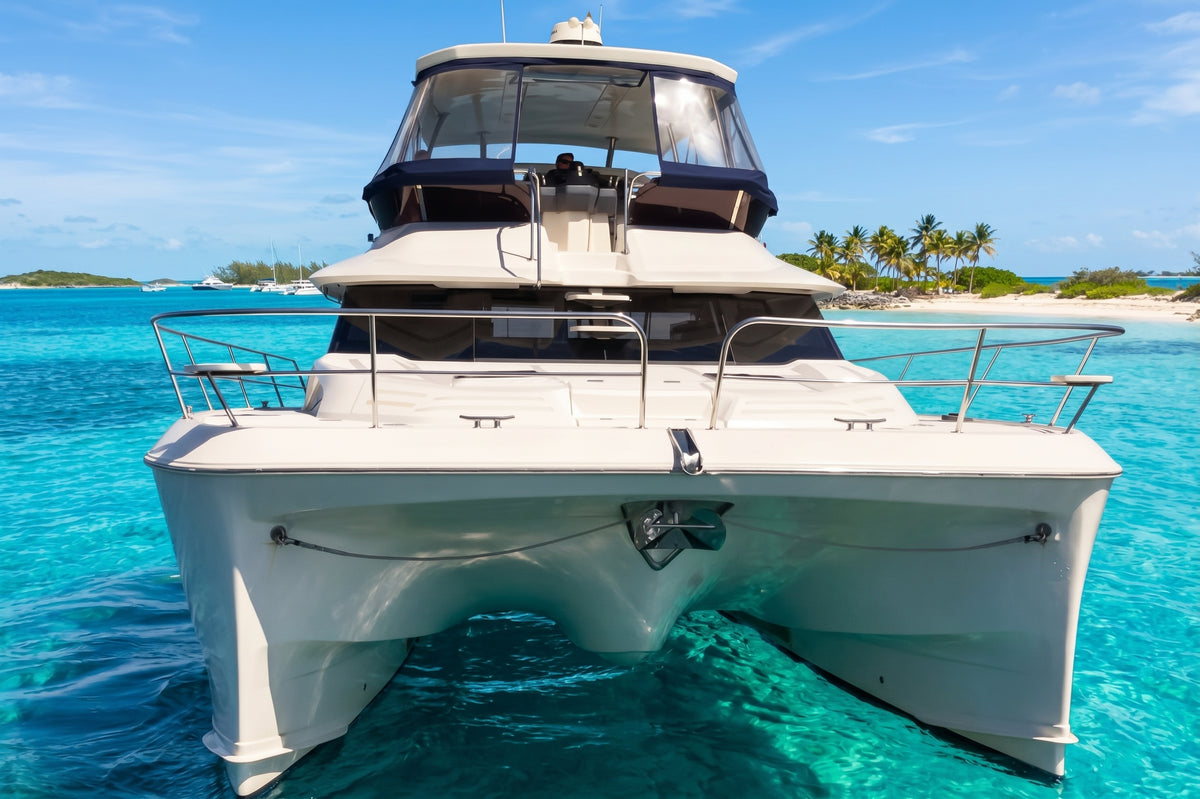 Bow-on view of Let it be 3, a 44ft Aquila power catamaran, showing both hulls over shallow water