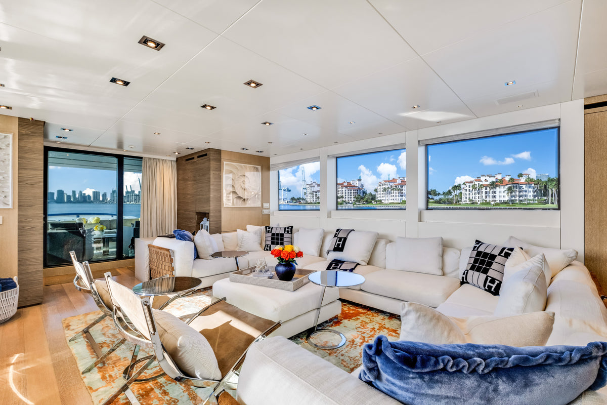 Main saloon aboard ASTONISH, pale oak joinery and panoramic windows over the Miami waterfront