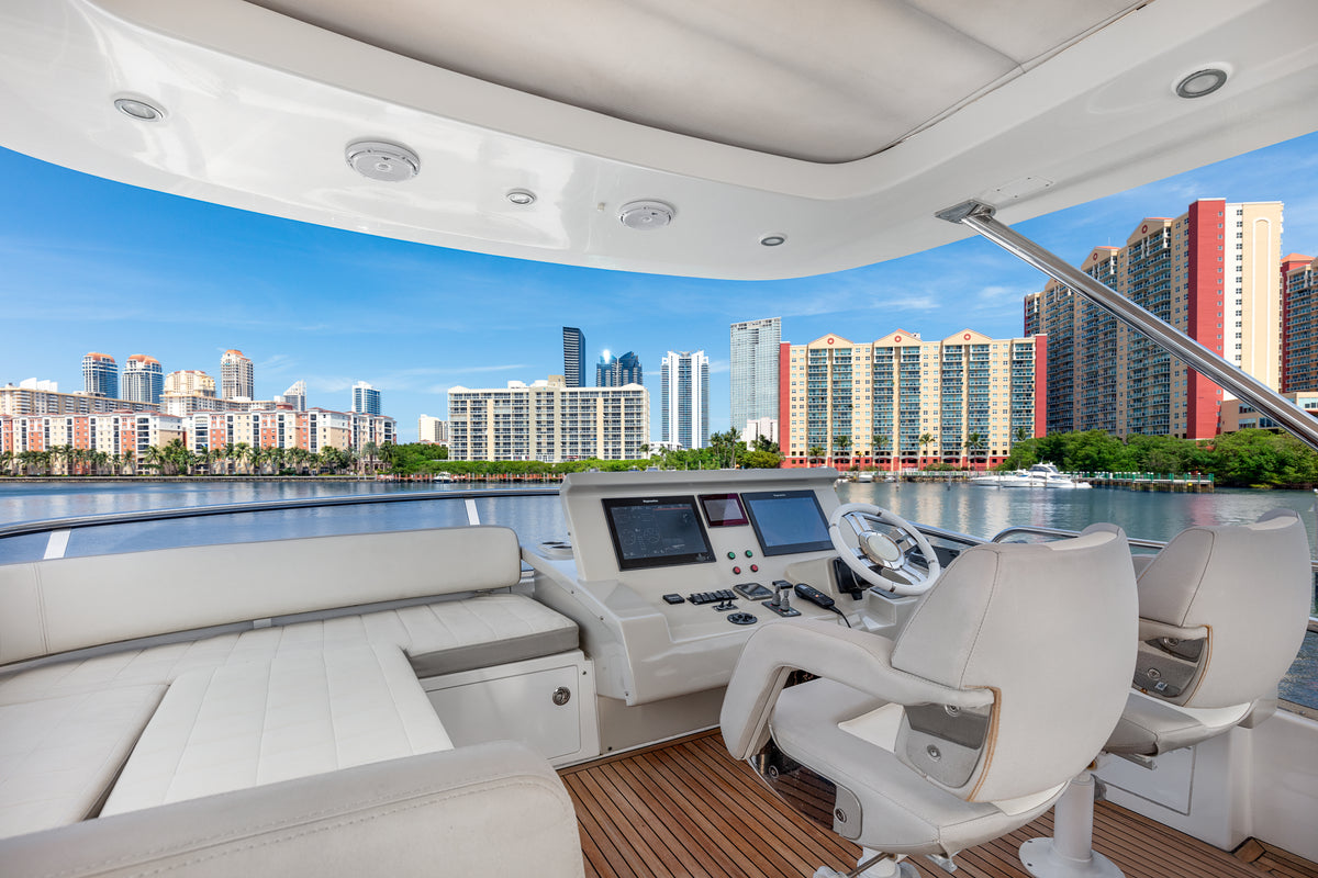Flybridge helm station on Le Grand Bleu, with twin captain's chairs and a Miami skyline view