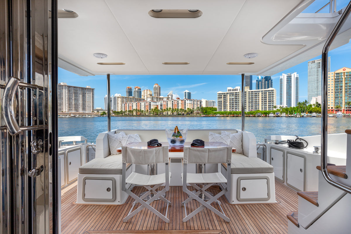 Shaded aft deck dining area on Le Grand Bleu, set for guests with a Miami waterfront view