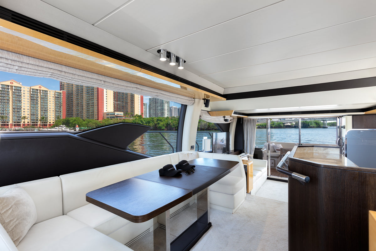 Saloon dining area on Le Grand Bleu, with a dark wood table and full-height windows