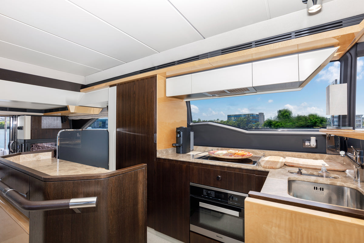 Galley on Le Grand Bleu, with dark wood cabinetry, an oven and a full-size sink