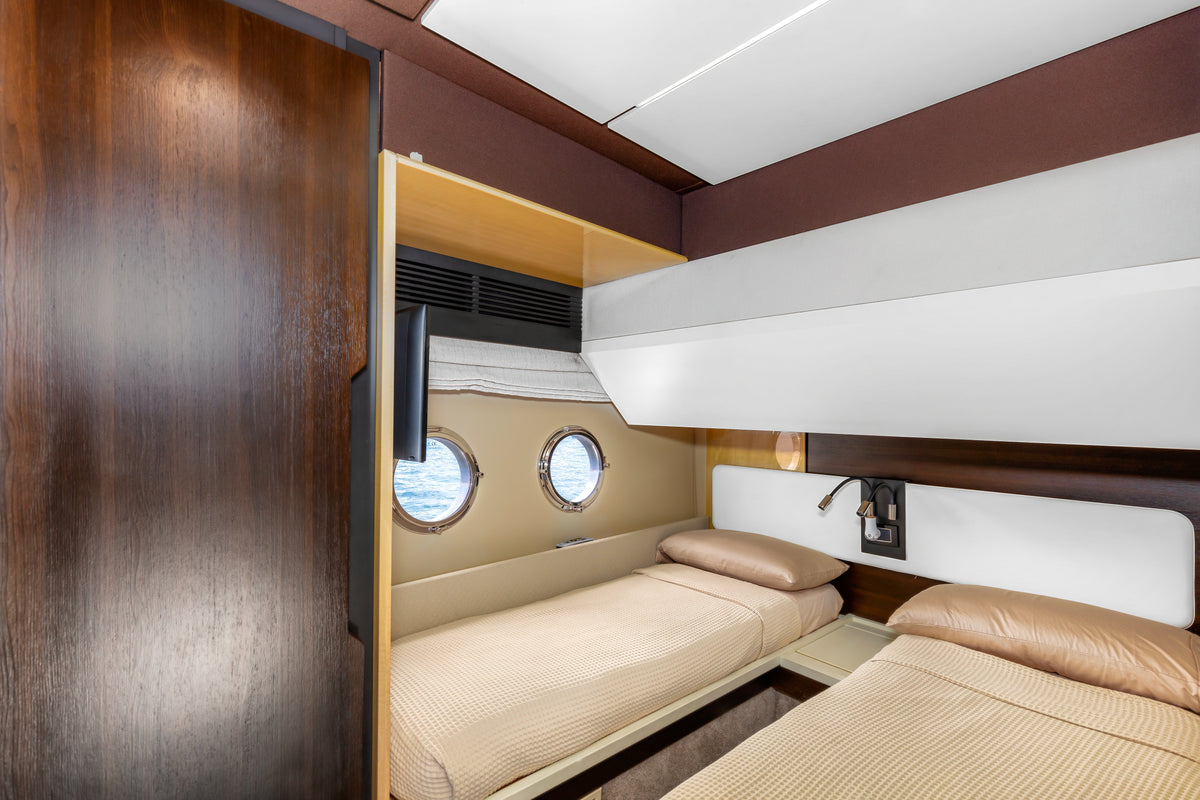 Twin guest cabin on Le Grand Bleu, with two single beds and portholes