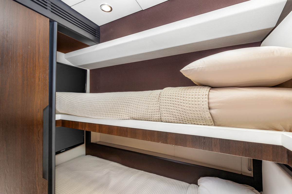 Bunk cabin on Le Grand Bleu, with two stacked berths finished in dark wood