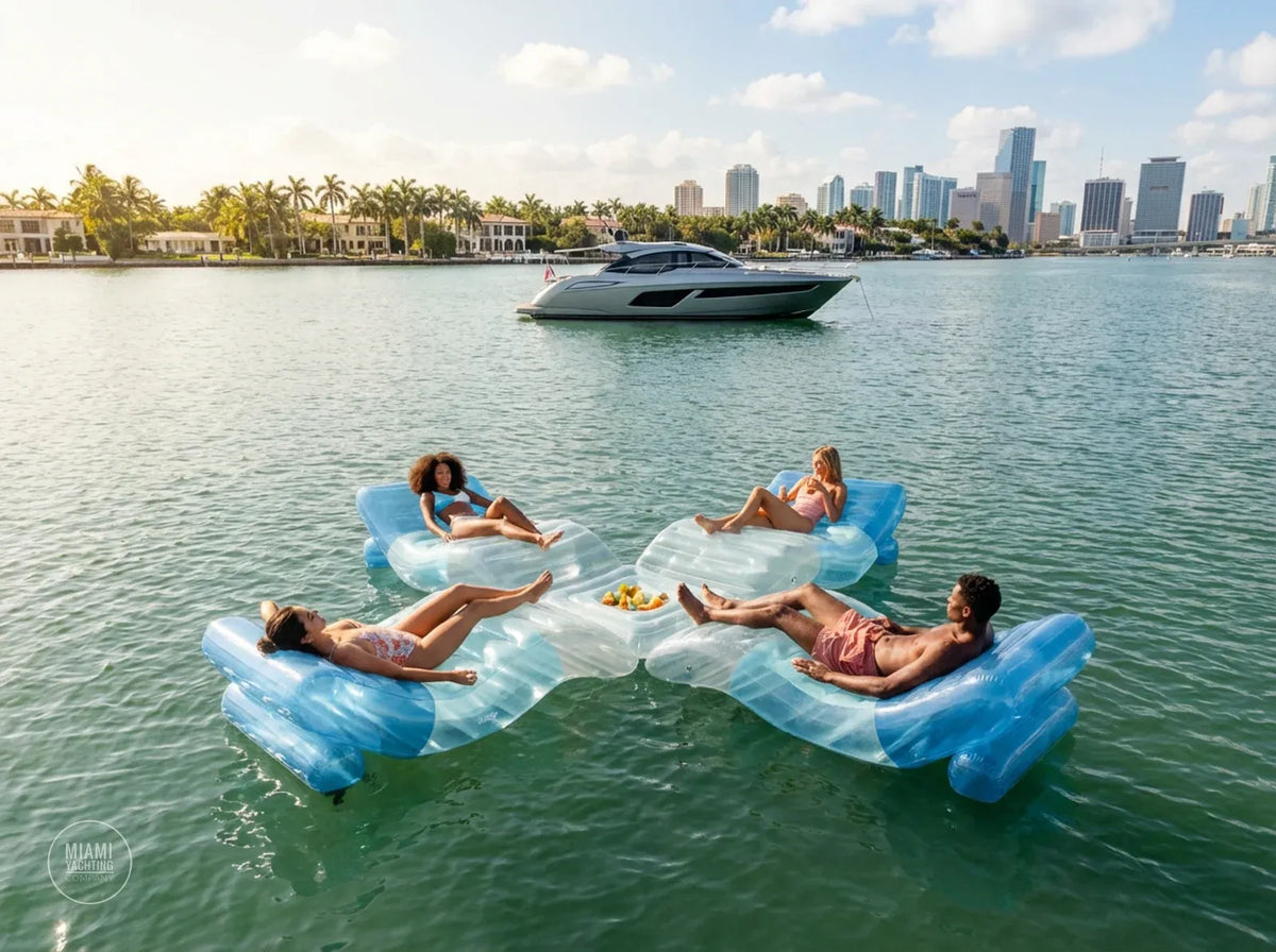 Guests relaxing on linked blue floating lounge chairs near a yacht
