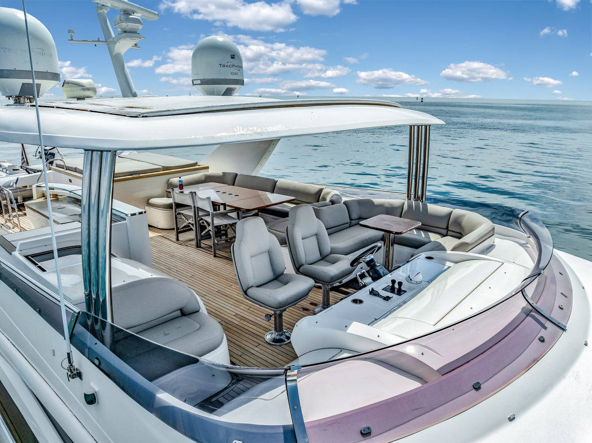 Flybridge helm chairs, dining table and wraparound sofa under the hardtop aboard PRAYING FOR OVERTIME