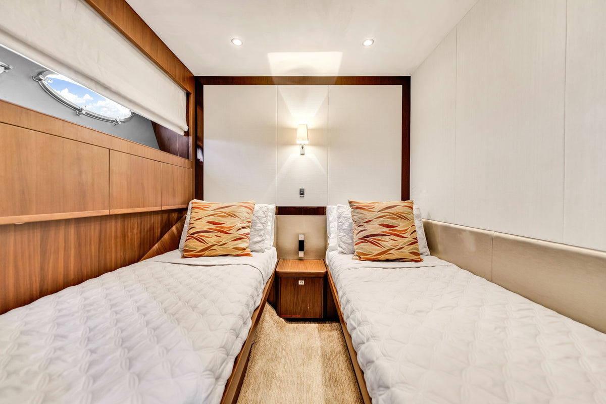 Twin guest cabin on PRAYING FOR OVERTIME with two single berths, reading lights and a porthole
