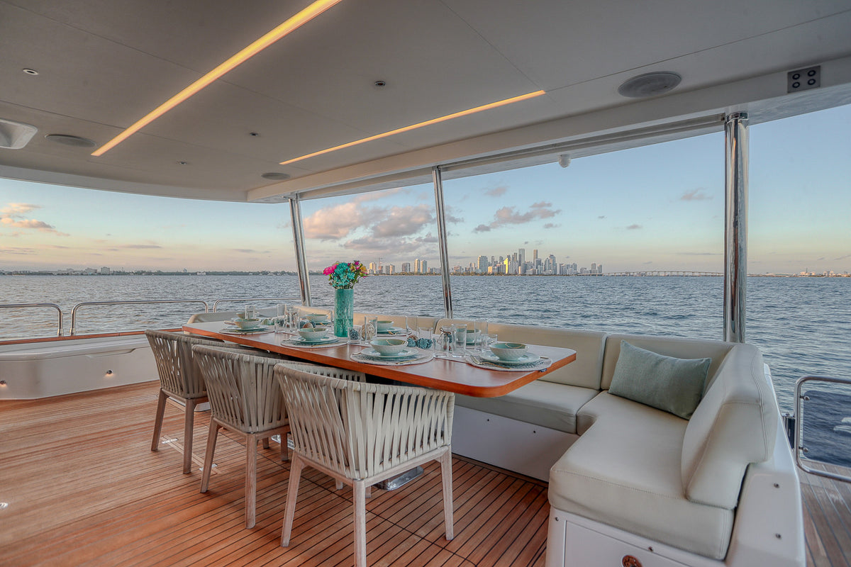 Aft deck dining aboard SAINT, an 88ft Sirena, with a shaded table for guests