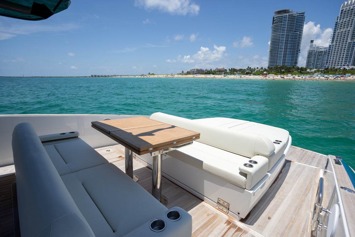 Cockpit lounge and teak table on the Solaris Power, Miami skyline in the distance