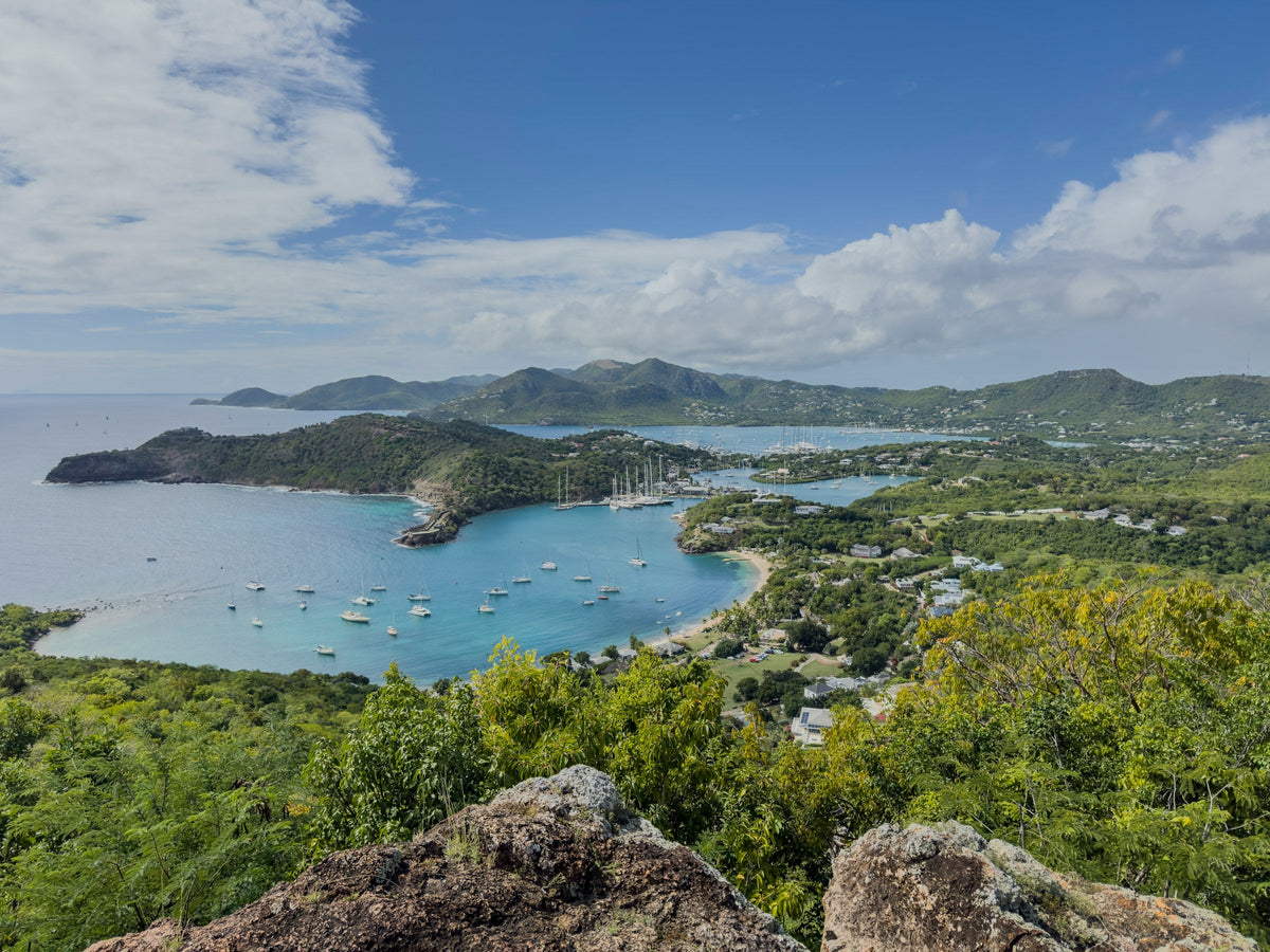 Sailing yachts anchored beneath green hills in English Harbour, Antigua.