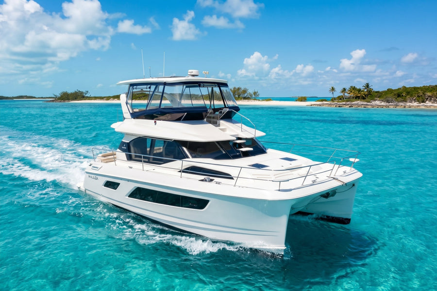 Let it be 3, a 44ft Aquila power catamaran, cruising over turquoise water off a Bahamas island