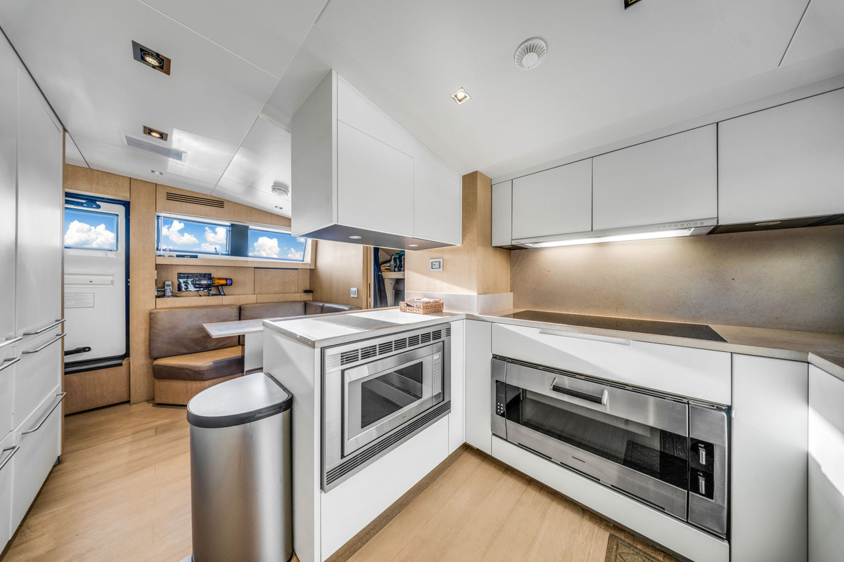 Crew galley aboard ASTONISH, stainless appliances and stone worktops for full-service Miami charters