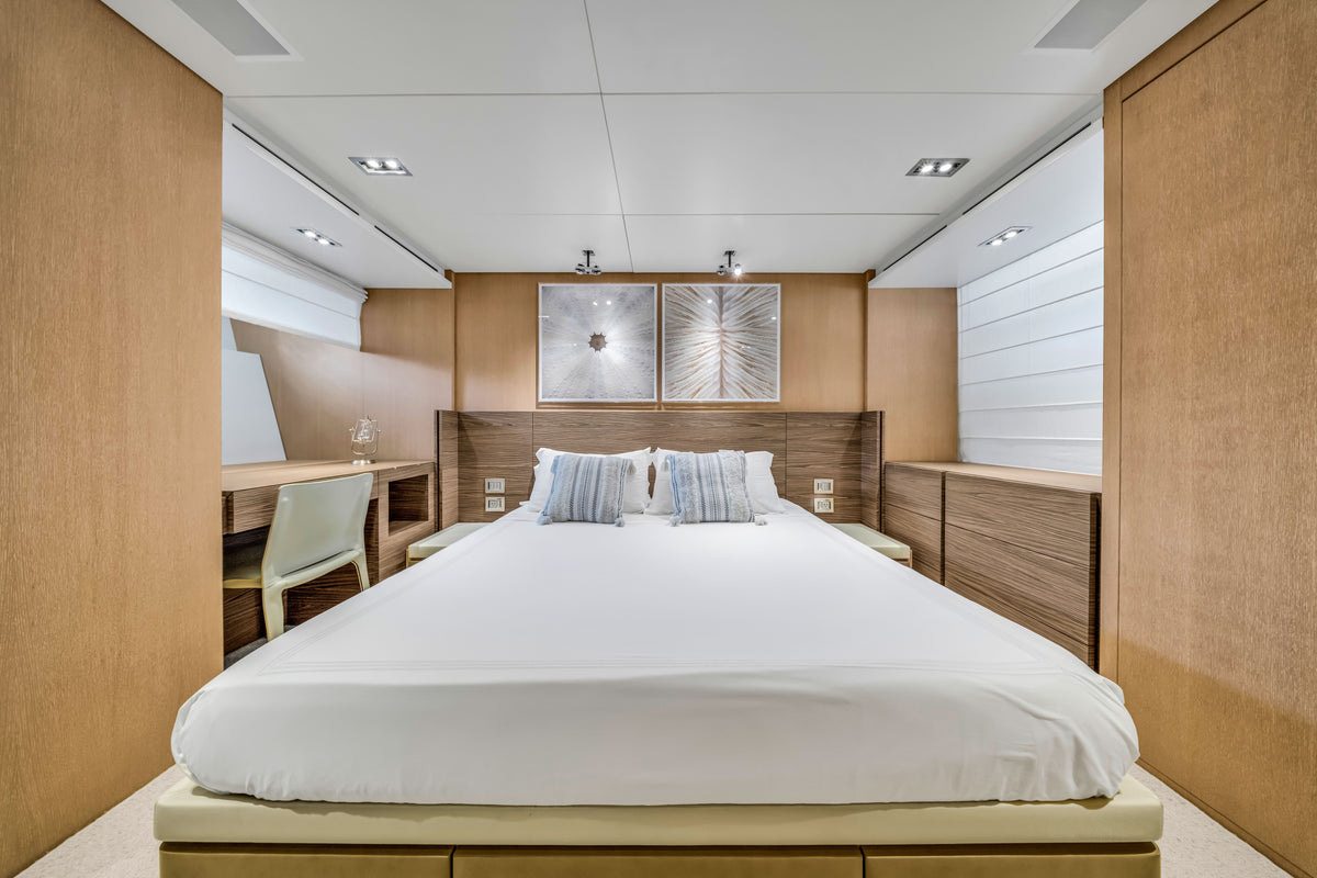 VIP stateroom forward aboard ASTONISH, double berth under a curved oak headboard