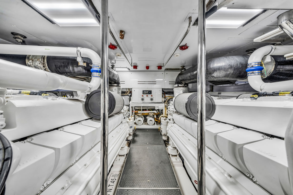 Engine room of ASTONISH, twin MTU diesels in a clean white machinery space