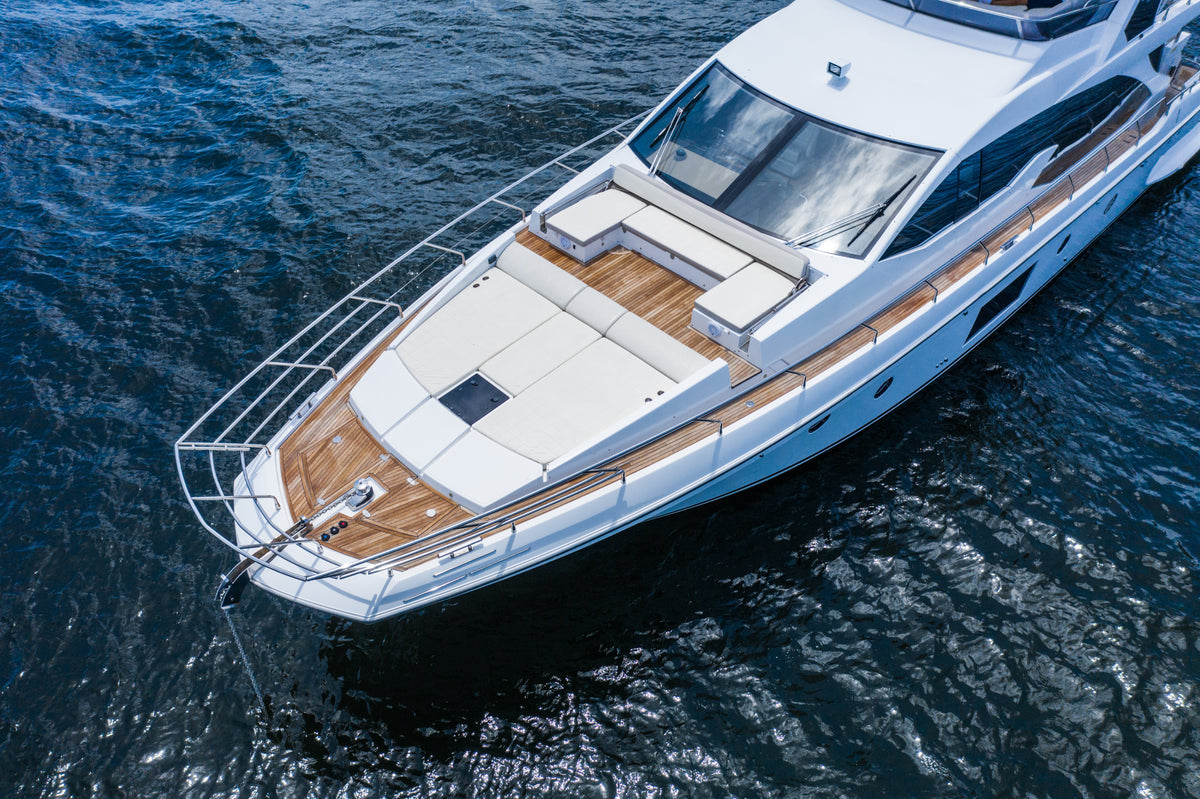 Bow view of Le Grand Bleu, a 68ft Azimut yacht, with the foredeck sunpad and teak side decks