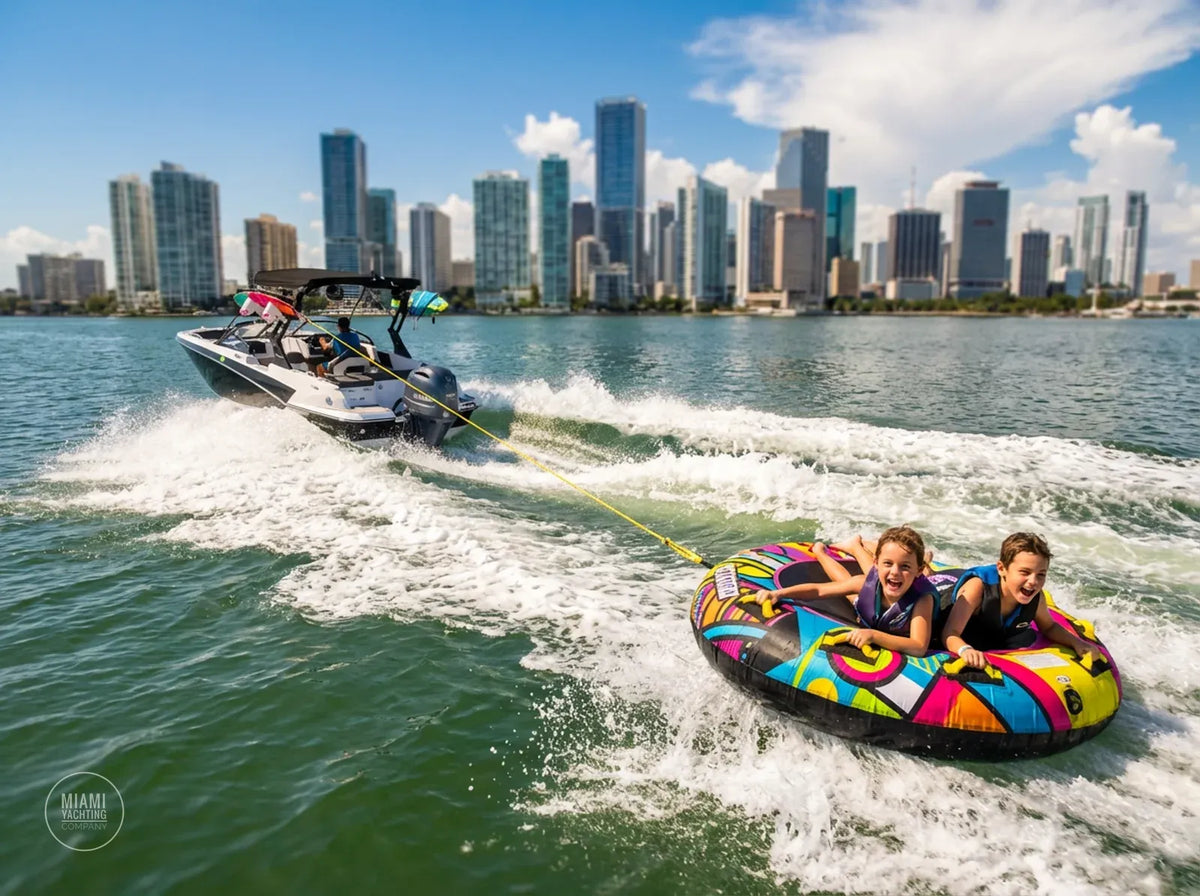 Water sports boat towing a tube with riders in front of the Miami skyline