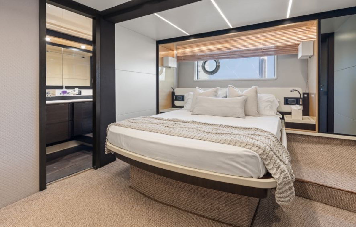 Master stateroom on Paragon with a queen bed, hull window and en suite bathroom