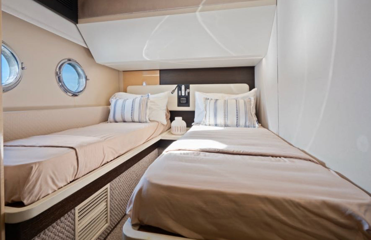 Twin guest cabin on Paragon with portholes and two single beds