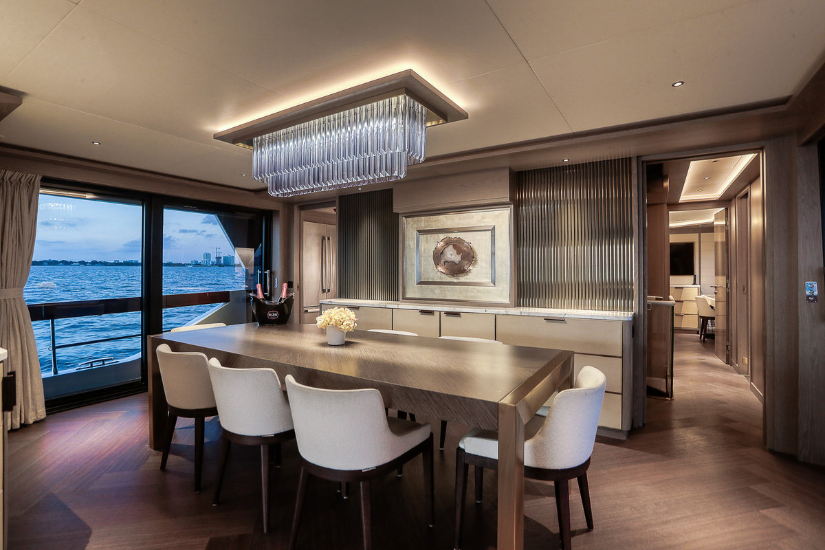 Formal dining table in SAINT's main-deck saloon, set for a Miami charter