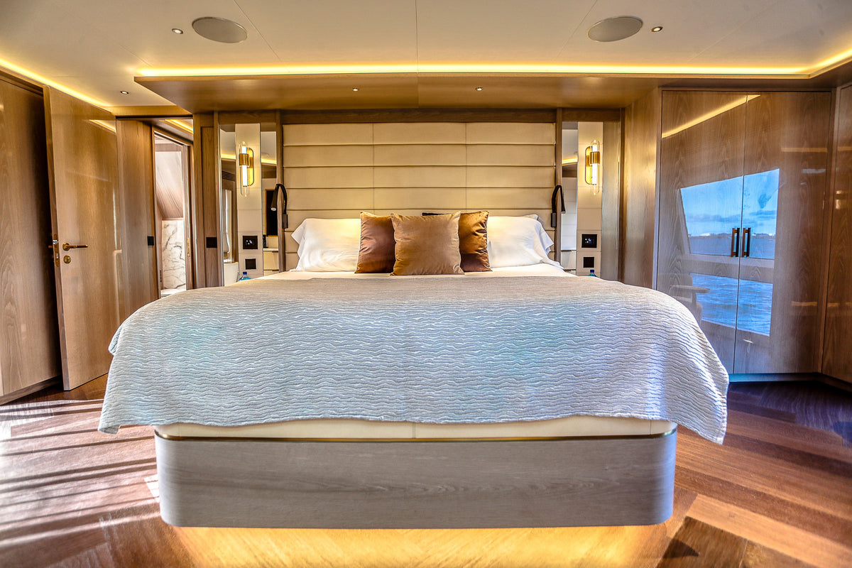 Full-beam master stateroom aboard SAINT with hull windows and a king berth