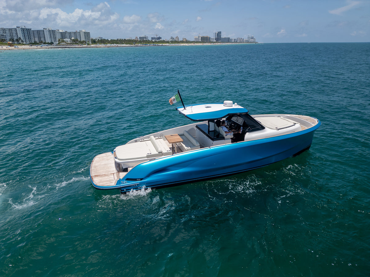 Solaris Power Sport Turismo cruising off Miami Beach, profile view of her metallic blue hull