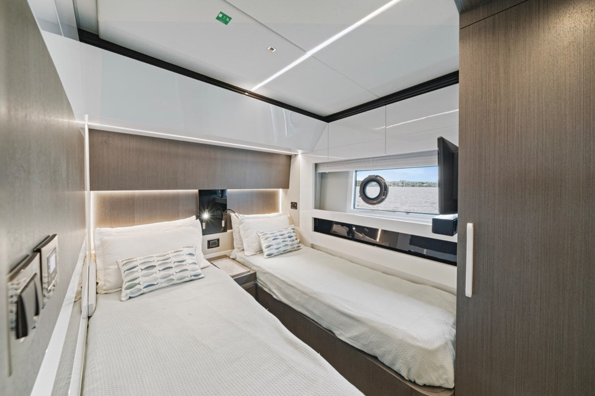Twin cabin on Water You Doing with two single beds and a porthole